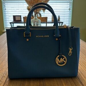 Michael Kors medium size tote. The outside is blue with gold fixtures.